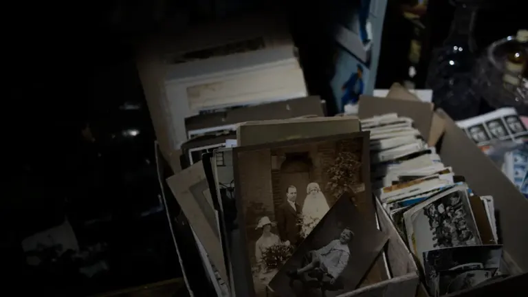 A box filled with old vintage black and white family photographs and heirlooms.