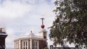 The historic Greenwich Observatory building featuring its iconic red time ball and weather vane.