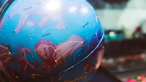 A stylized celestial globe featuring constellation illustrations and zodiac signs under dim lighting.
